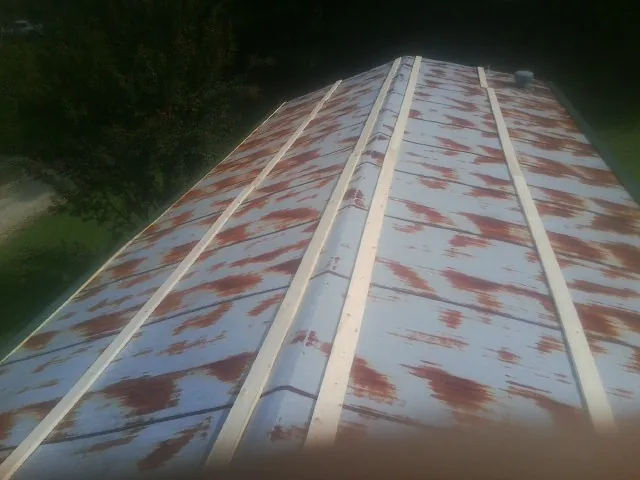 Rusted metal roof panels with new wood purlins before replacement — Storm Damage Roof Repair in Daisetta by Roofing Brothers